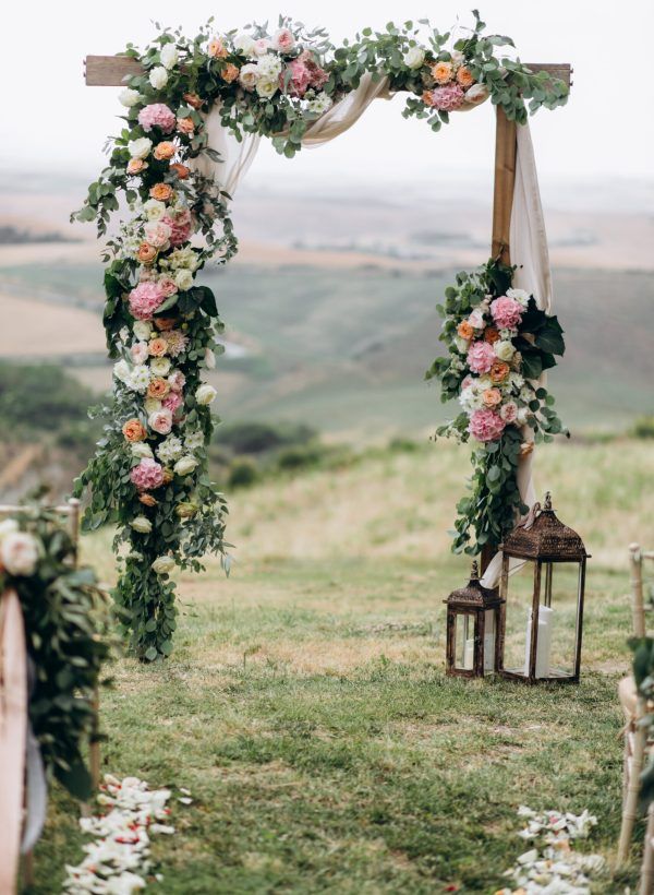 Beautiful archway decorated with floral composition outdoors